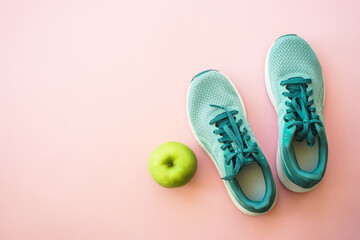 Wall Mural - Workout and healthy lifestyle concept. Sneakers, green apple and bottle of water. Flat lay with copy space.