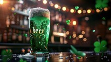 A Glass Of Traditional Irish Green Beer For St. Patrick's Day Stands On The Bar Counter, Next To A Clover Leafs. With The Text "beer" On The Glass