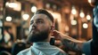 man with big beard getting his hair cut in a barbershop with a professional barber in a nice salon