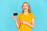 Fototapeta  - Happy woman pointing at bank card with amazing and easy customer service