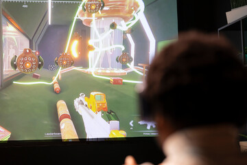 Man playing science fiction shooter videogame in apartment, holding joystick. Gamer participating in online esports tournament using professional gamepad and headphones to increase win chances