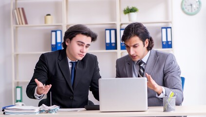 Wall Mural - Two young employees working in the office