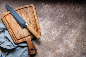 Wall Mural - wooden cutting board, knife and napkin on the kitchen table. Space for text.