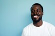 © Anna - Portrait of a cheerful african american man with a bright and genuine smile, his casual white t-shirt symbolizing a laid-back and content lifestyle..