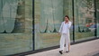 © stockbusters - Elegant businesswoman talking mobile phone going to office. Woman ending call