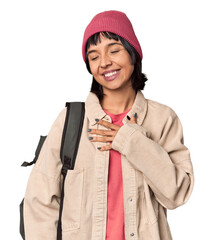 Wall Mural - Young student with backpack and beanie in studio happy, smiling and cheerful.