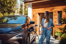 Woman Standing Next to Brown Car, Electric Vehicle