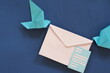 Two birds paper origami carrying letter envelope. Receiving email or mail such as invitation and announcement or memo concept.