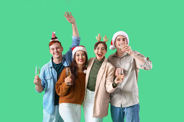 Canvas Print - Group of friends with champagne on green background. New Year celebration