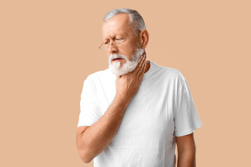 Wall Mural - Ill old man with sore throat on beige background