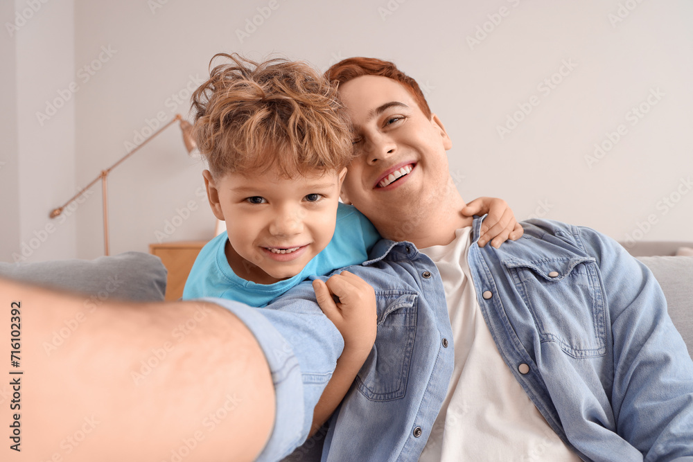 Little boy with his father taking selfie at home, closeup