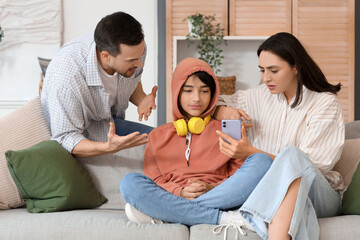 Wall Mural - Teenage boy and his parents with mobile phone at home. Family problem concept