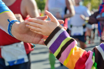 Wall Mural - Marathon running race, supporting runners on road, child hand giving highfive, sport concept
