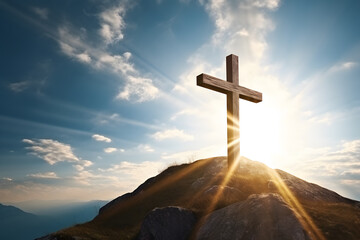 Wooden religious cross at top of mountain hill with sunbeams