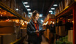 © Crowded Studio - Joven trabajadora con uniforme. Gestión de lista de comprobación paquete de productos de salida en el almacén. Empleada con tableta en mano trabajando en un almacén. Concepto logístico de importación