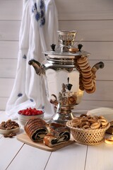 Wall Mural - Traditional Russian samovar and treats on white wooden table