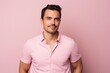© MediaRaw - Portrait of handsome young man in pink polo shirt on pink background.
