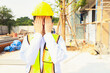 © ฺฺฺBoonterm - Female workers covering their faces with their hands have health problems eye irritation problems from dust and and excessive air pollution at construction sites : Work sites without safety equipment.