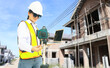 © ฺฺฺBoonterm - Female foremam in sunglasses holding laptop computer and checking modern technology tools, laser level and vertical marker (plum bob) on stand at construction site, large housing project.