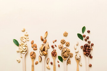 Poster - mixed nuts in white wooden spoon. Mix of various nuts on colored background. pistachios, cashews, walnuts, hazelnuts, peanuts and brazil nuts