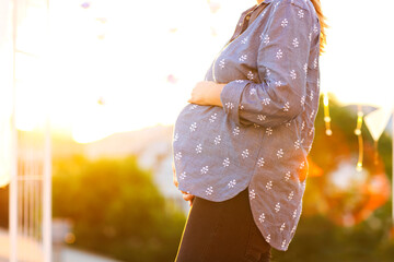 Wall Mural - Pregnant woman against backdrop of city