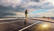 © ฺฺฺBoonterm - Engineer asian male electrician inspects the installation solar panels metal roof in an industrial factory walk around inspect important points each solar cell panel and record data on a clipboard.