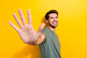 Poster - Photo of friendly good mood man with bristle dressed khaki t-shirt giving you highfive isolated on vibrant yellow color background