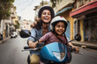 © AJay - A happy smiling mother and child travelling in a scooter through the streets