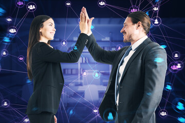 Aufkleber - Side view of happy businessman and woman hi-fiving with connected digital people team icons on dark blurry purple office interior background. Digital network, community and social media concept.