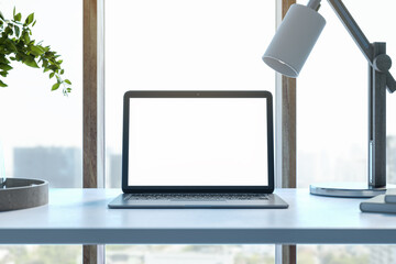 Poster - Modern designer desktop with white mock up laptop computer, various objects and window with city view in the background. 3D Rendering.
