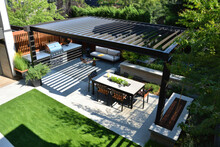 Modern Patio Furniture Includes A Pergola Shade Structure, An Awning, A Patio Roof, A Dining Table, Seats, And A Metal Grill, Grass Lawn And Glowers Garden