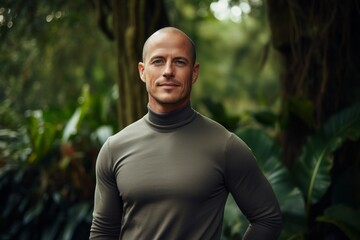 Wall Mural - Portrait of a glad man in his 40s wearing a classic turtleneck sweater against a lush tropical rainforest. AI Generation
