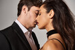 © LIGHTFIELD STUDIOS - passionate couple, brunette young woman with red lips kissing with handsome man on grey background