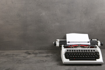 Fototapete - vintage typewriter on the table with blank paper on the grey desk - concept for writing, journalism, blogging