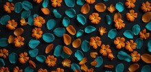  A Group Of Orange And Teal Flowers On A Black Background With A Blue Center Surrounded By Smaller Orange And Teal Petals On The Top Of The Petals Of The Petals.