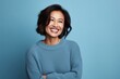 © CogniLens - Portrait of a cheerful asian woman in her 40s wearing a cozy sweater against a soft blue background. AI Generation