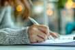 © atitaph - Close-up of woman's handwriting on paper in the office. Notebook or diary with a ballpoint pen in Communication and business concepts at marketing business investment