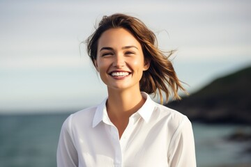 Wall Mural - Portrait of a happy woman in her 20s wearing a classic white shirt against a calm bay background. AI Generation