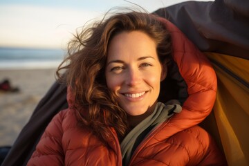 Poster - Portrait of a blissful woman in her 30s sporting a quilted insulated jacket against a relaxing hammock on the beach background. AI Generation