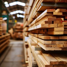  Large Stack Of Wooden Planks In A Warehouse Or Workshop Area With A Blurred Background Of Wood Planks