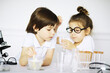© alexkich - Two cute children at chemistry lesson making experiments on white background