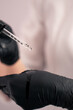 © Guys Who Shoot - close-up beautician squeezes facial serum from a pipette during a cosmetic procedure in beauty salon