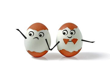 Two chicken eggs with shells and drawn faces and hands isolated on a white background. Comic decorated pair of eggs for a wedding in the form of a boy and a girl