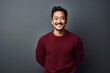 © CogniLens - Portrait of a cheerful asian man in his 30s dressed in a warm wool sweater against a minimalist or empty room background. AI Generation