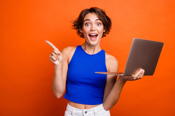 Aufkleber - Photo of excited funky girl dressed blue top rising fist chatting modern gadget empty space isolated orange color background