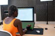© ADDICTIVE STOCK - Focused black woman using tablet in studio