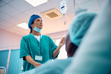 Wall Mural - Nurse taking care of patient at intensive care unit who is recovering in hospital