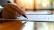© MP Studio - Close-up of a person's hands writing on a piece of paper with a pen