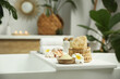 Bath tray with spa products and plumeria flower on tub in bathroom, space for text