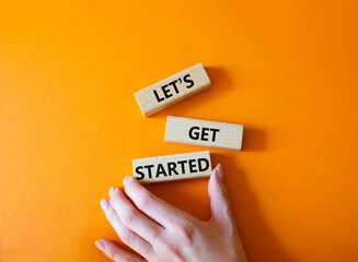 Wall Mural - lets get started symbol. concept words lets get started on wooden blocks. beautiful orange backgroun